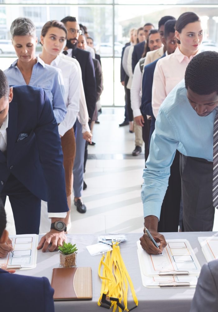 front-view-of-diverse-business-people-checking-in-at-conference-registration-table-in-office-lobby.jpg